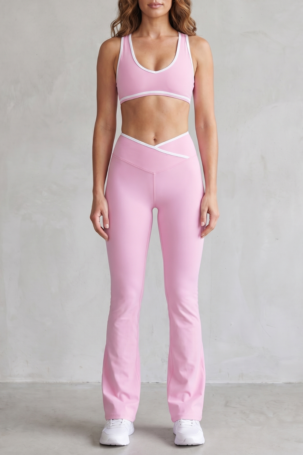 Pink colorway of the sports bra and flared leggings set, full-length view