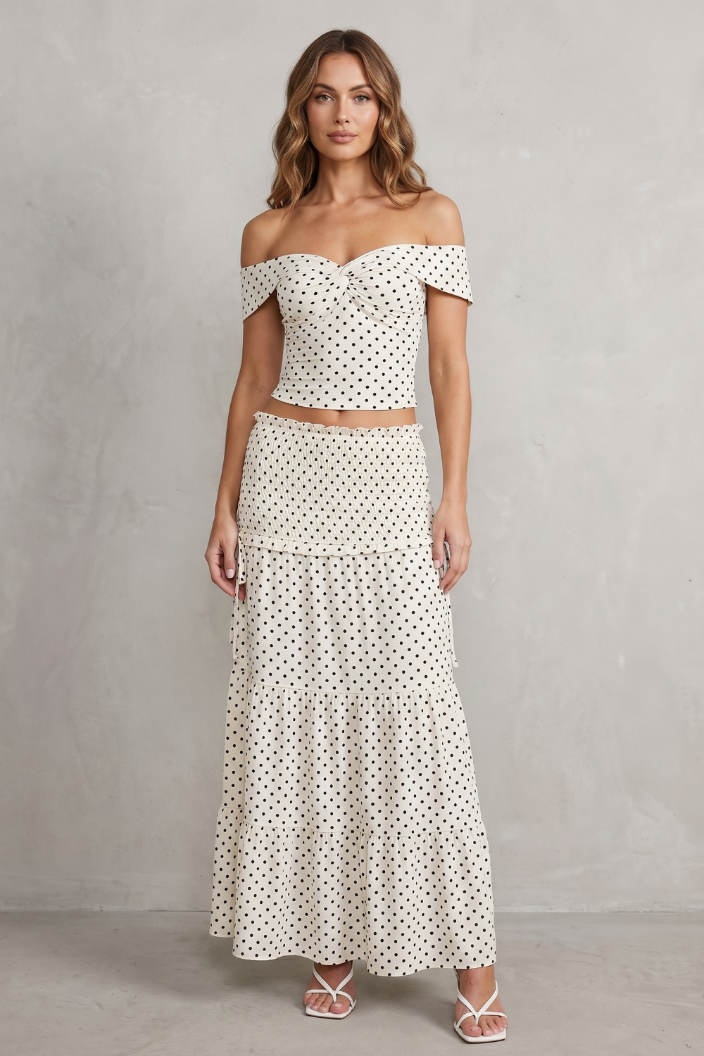 Side view of the polka dot off-shoulder top and ruched maxi skirt