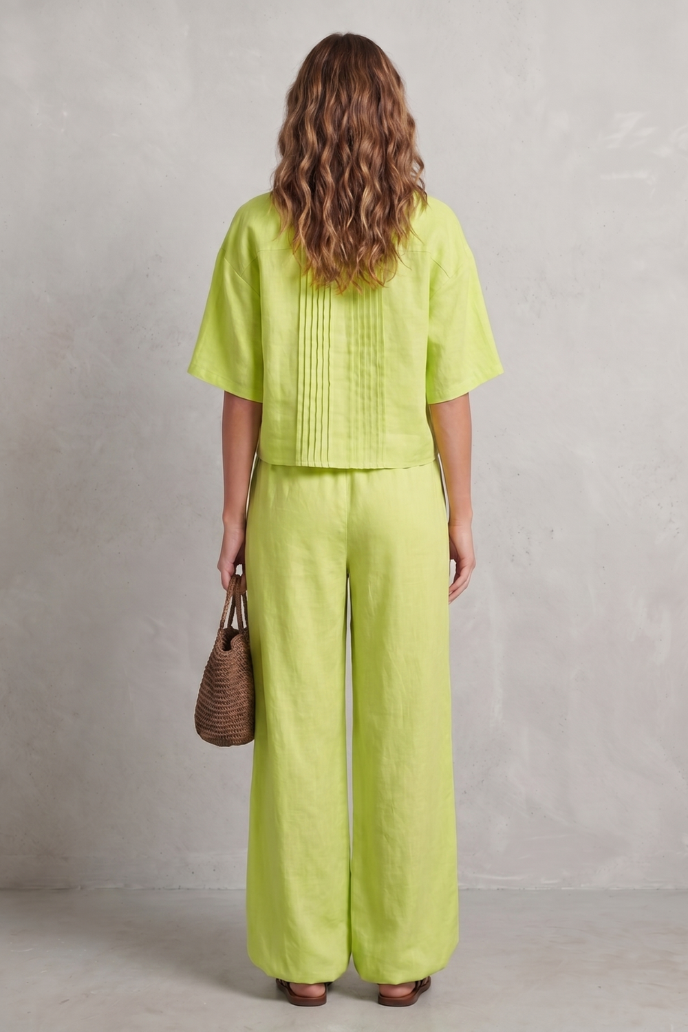 Detail close-up of the pleated front detailing on the wide-leg pants
