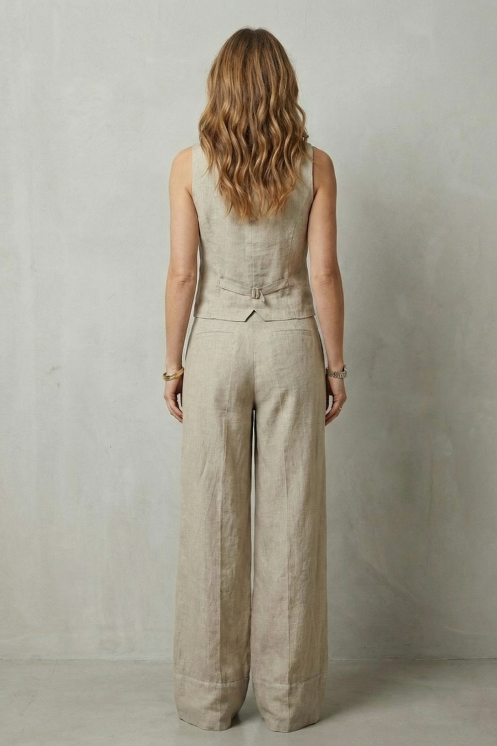 Close-up of the minimalist button detailing on the sleeveless tailored vest