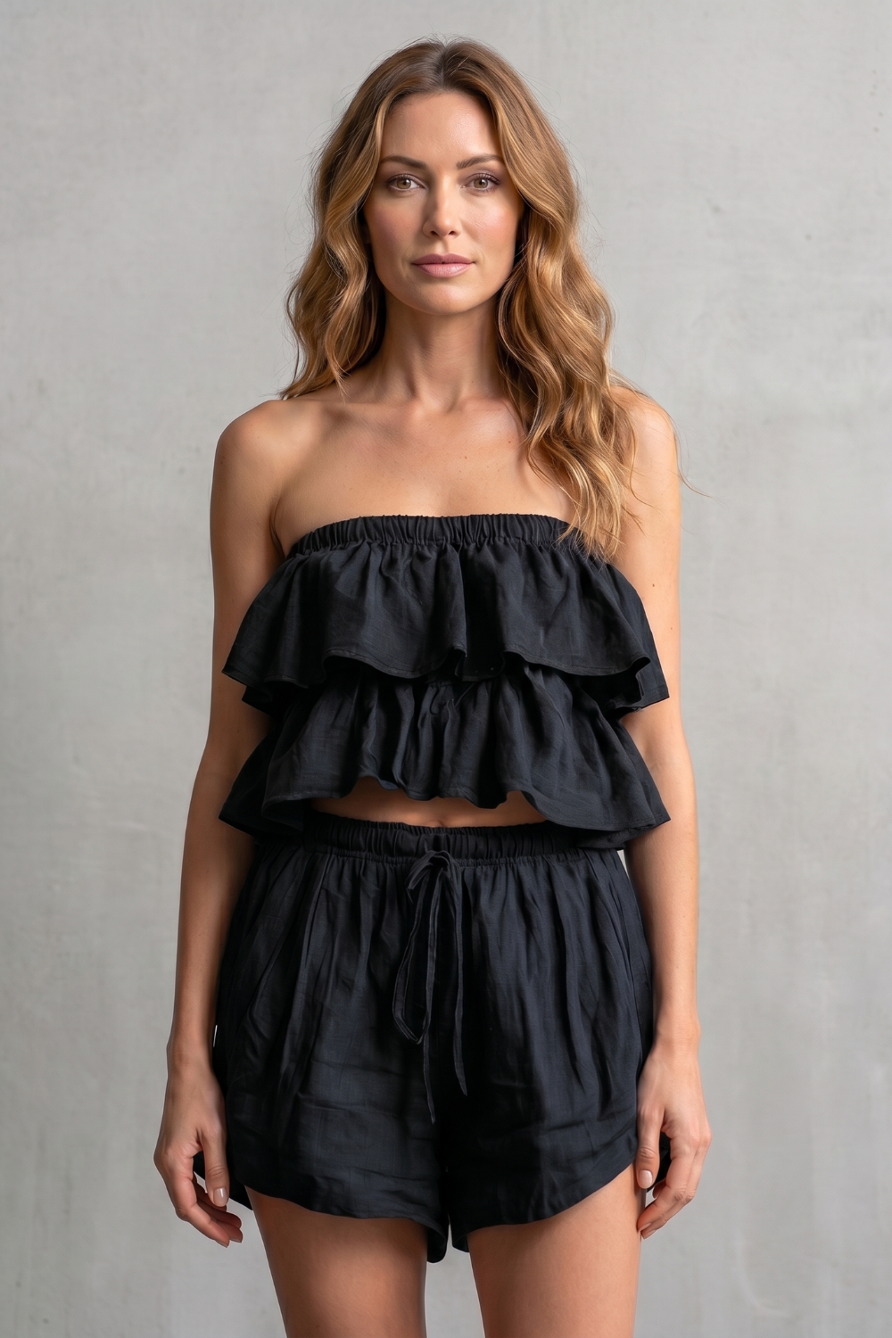 Black colorway of the ruffled bandeau top and shorts set, full-length view