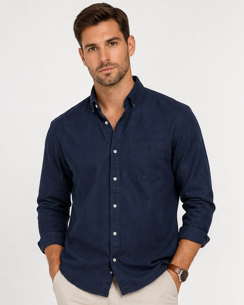 Man wearing a navy button-up shirt and beige pants on a white background