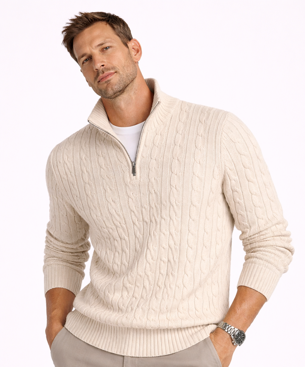 Man wearing a beige cable knit sweater with a white background