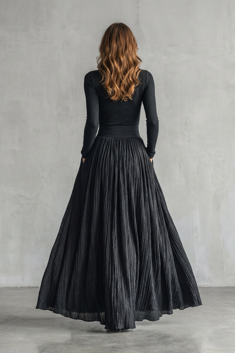 Detail close-up of the wide high-waisted waistband on the pleated skirt