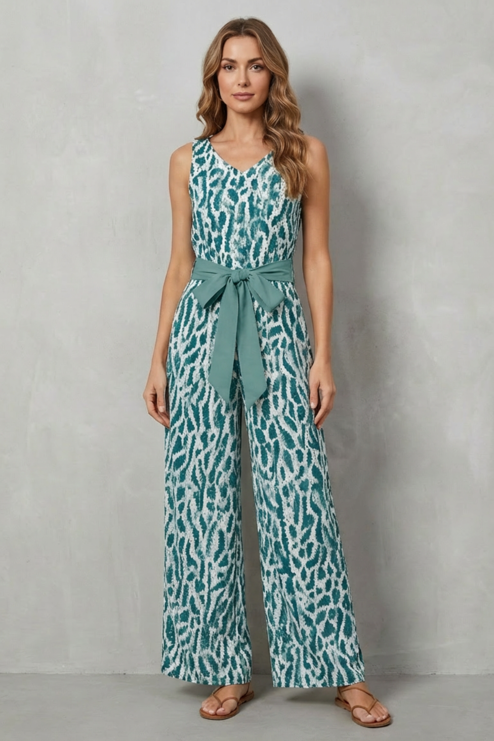 Printed jumpsuit styled with flat sandals and a straw hat