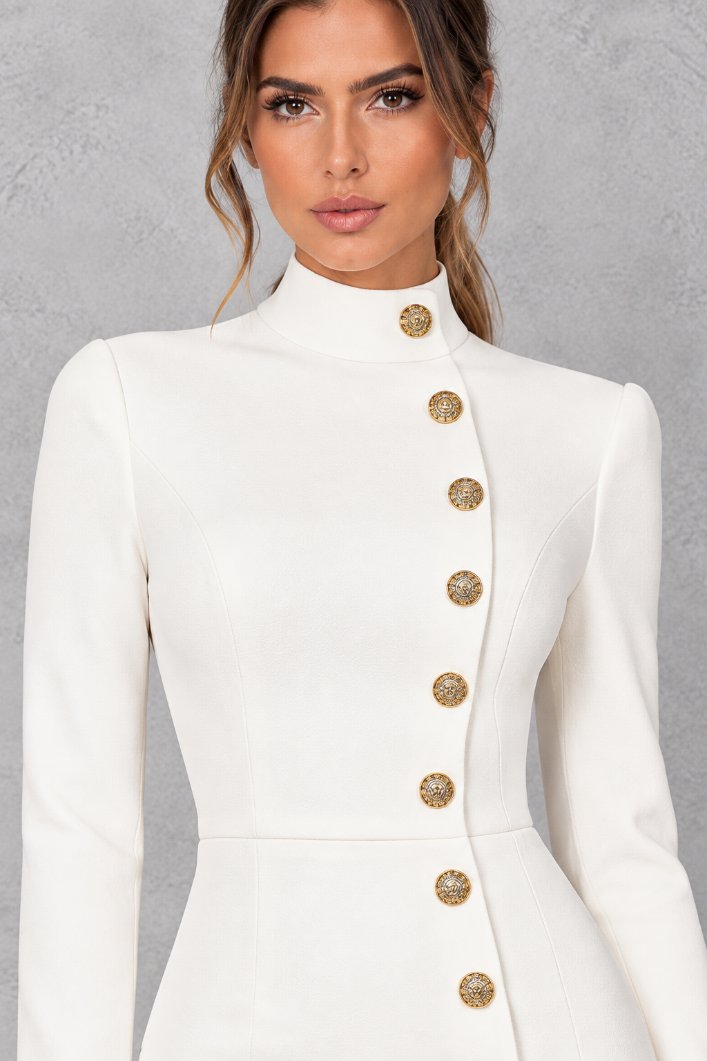 Close-up of the metallic button detail on a high neck mini dress.
