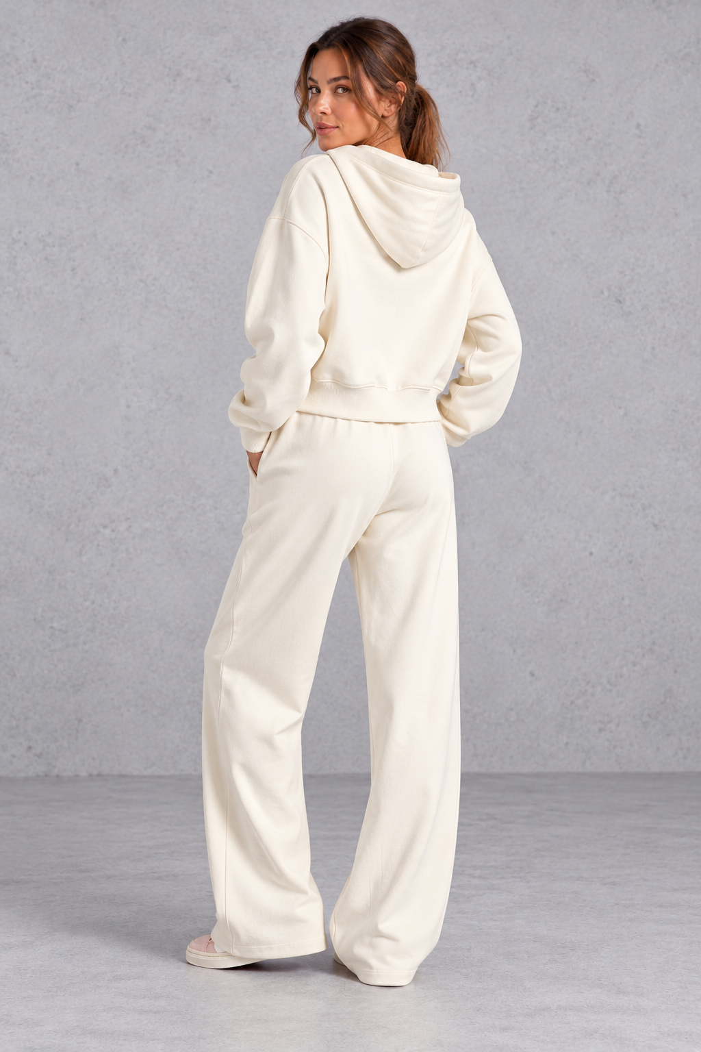 Cropped hoodie worn open over a fitted top with wide leg joggers