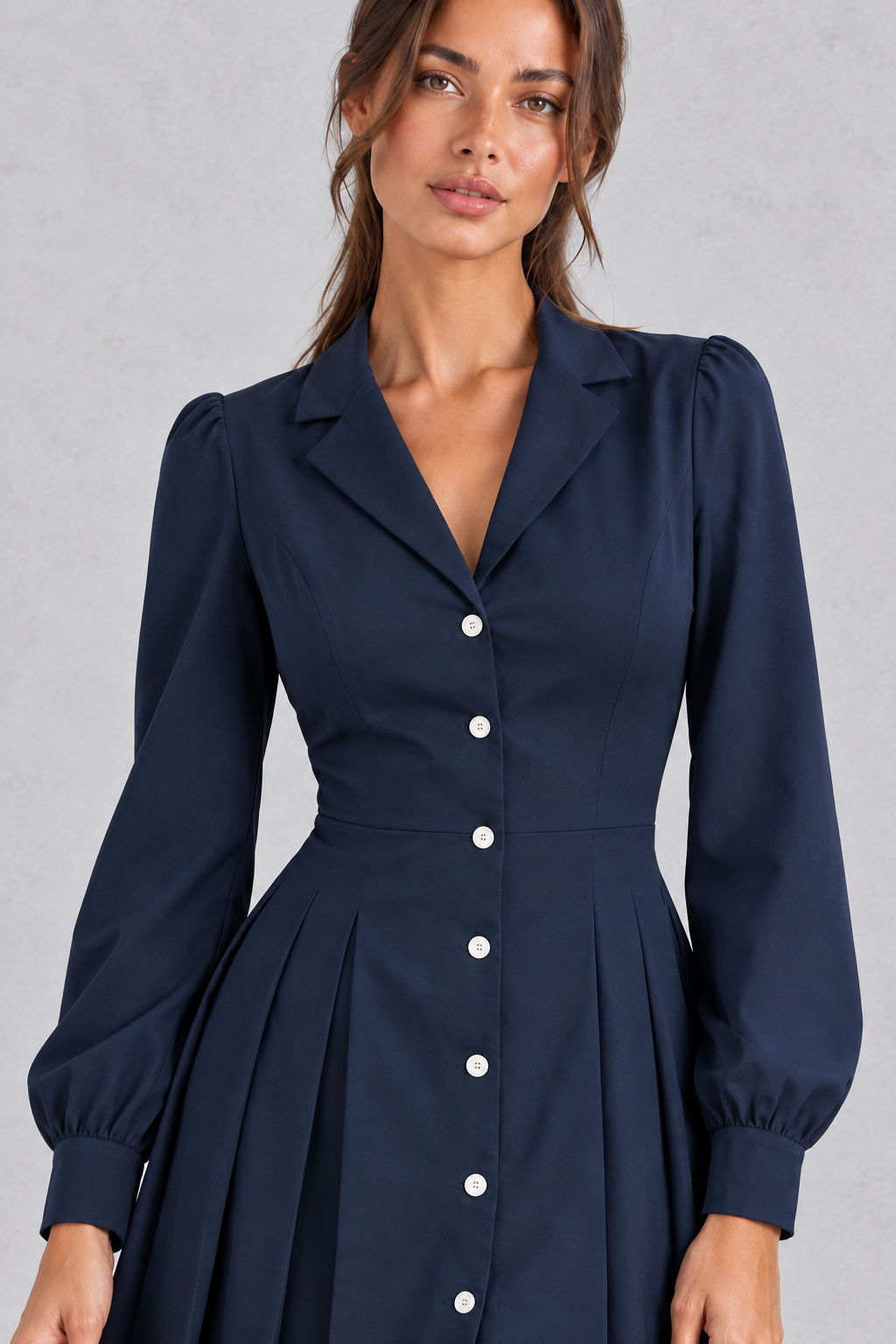 Close-up of the pleated skirt detail on a women's long sleeve shirt dress.
