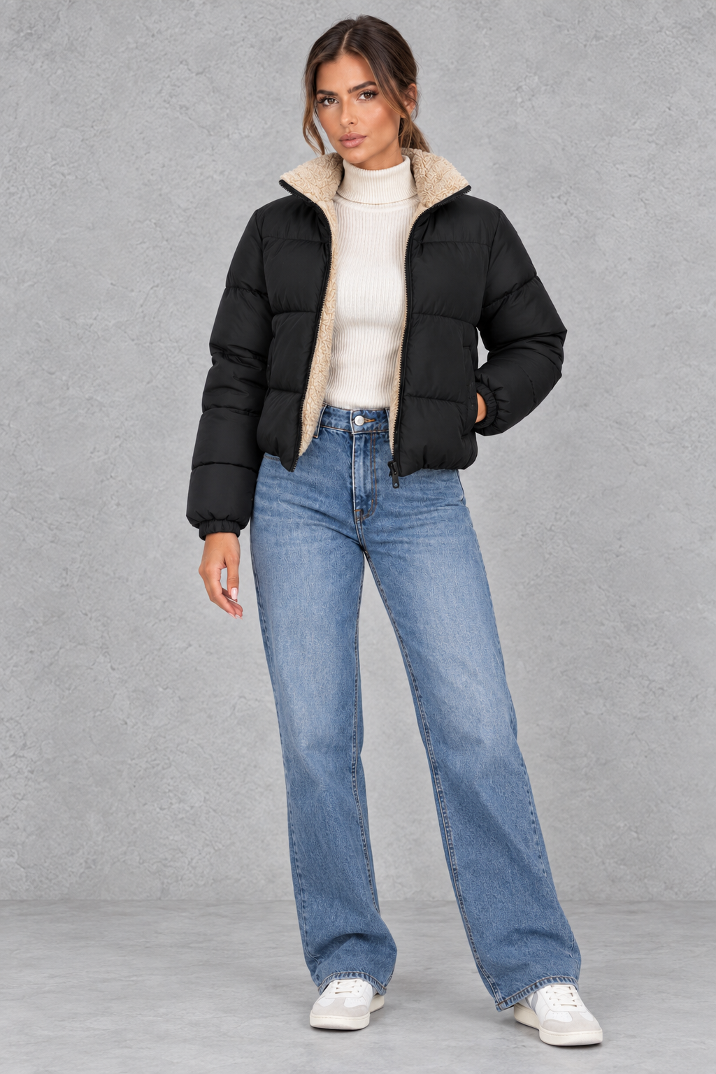 Short puffer jacket styled with high-waisted jeans and boots