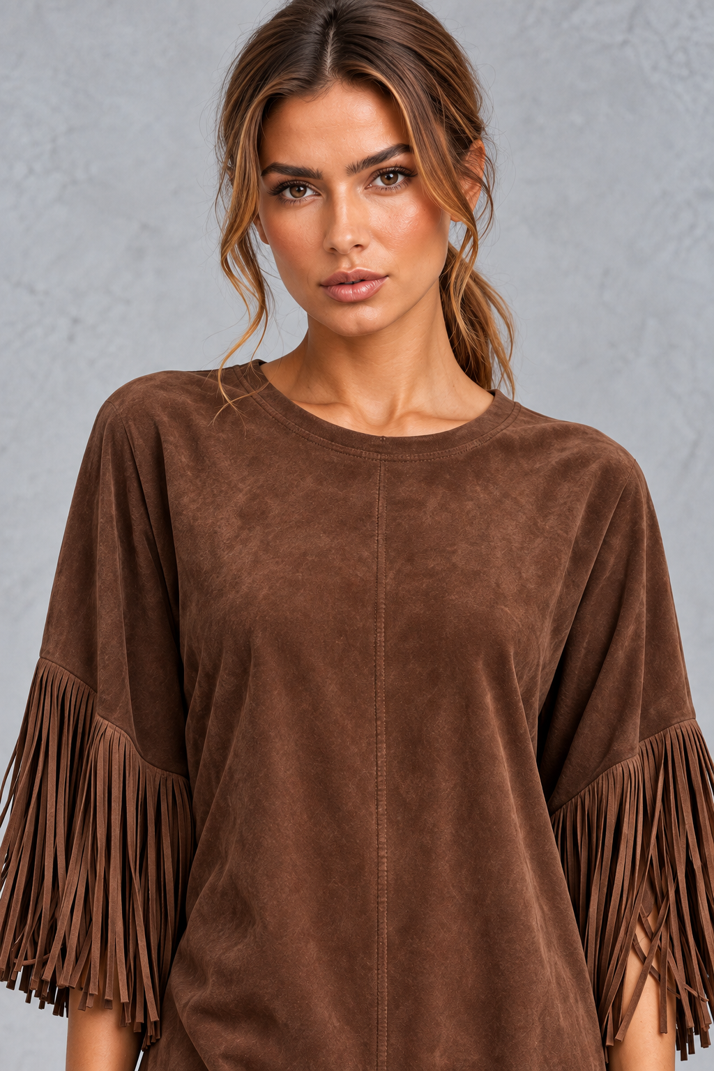 Close-up of fringe trim on the elbow-length sleeve of a women's suede-look dress