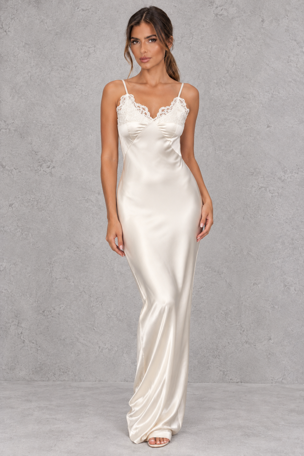 Woman wearing a white satin backless maxi dress with lace patchwork, ideal for evening events.