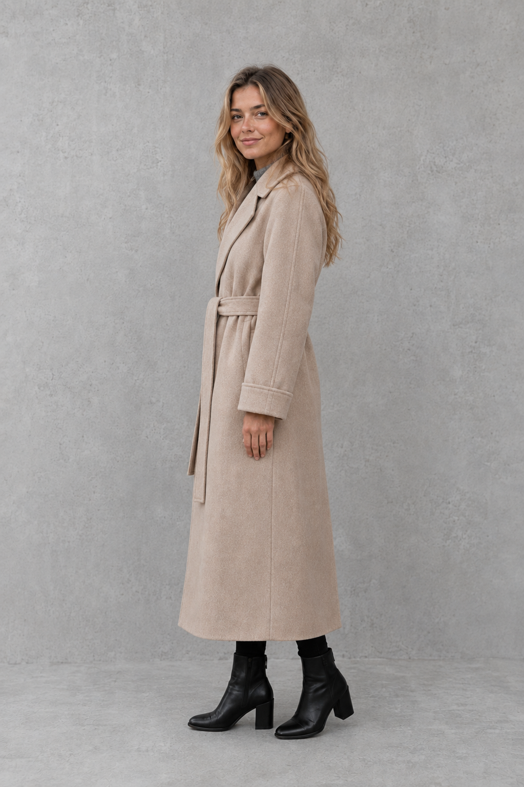 Women’s belted longline wrap coat with a classic lapel collar, adjustable waist tie, straight-cut silhouette, and structured tailored finish.