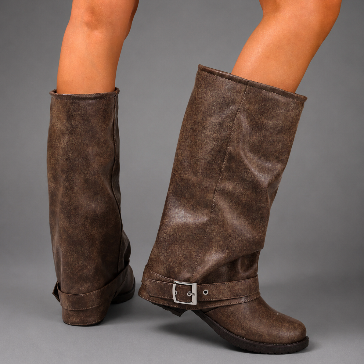 Women’s black slouch knee-high boots with a smooth faux leather upper, round toe, buckle strap detail, low block heel, and chunky lug sole.