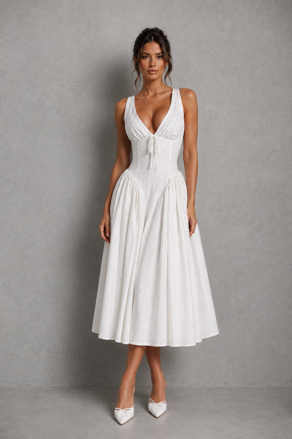 Women’s white broderie anglaise midi dress with plunge neckline, gathered bust, adjustable straps, lace-up back, and flowing godet skirt.