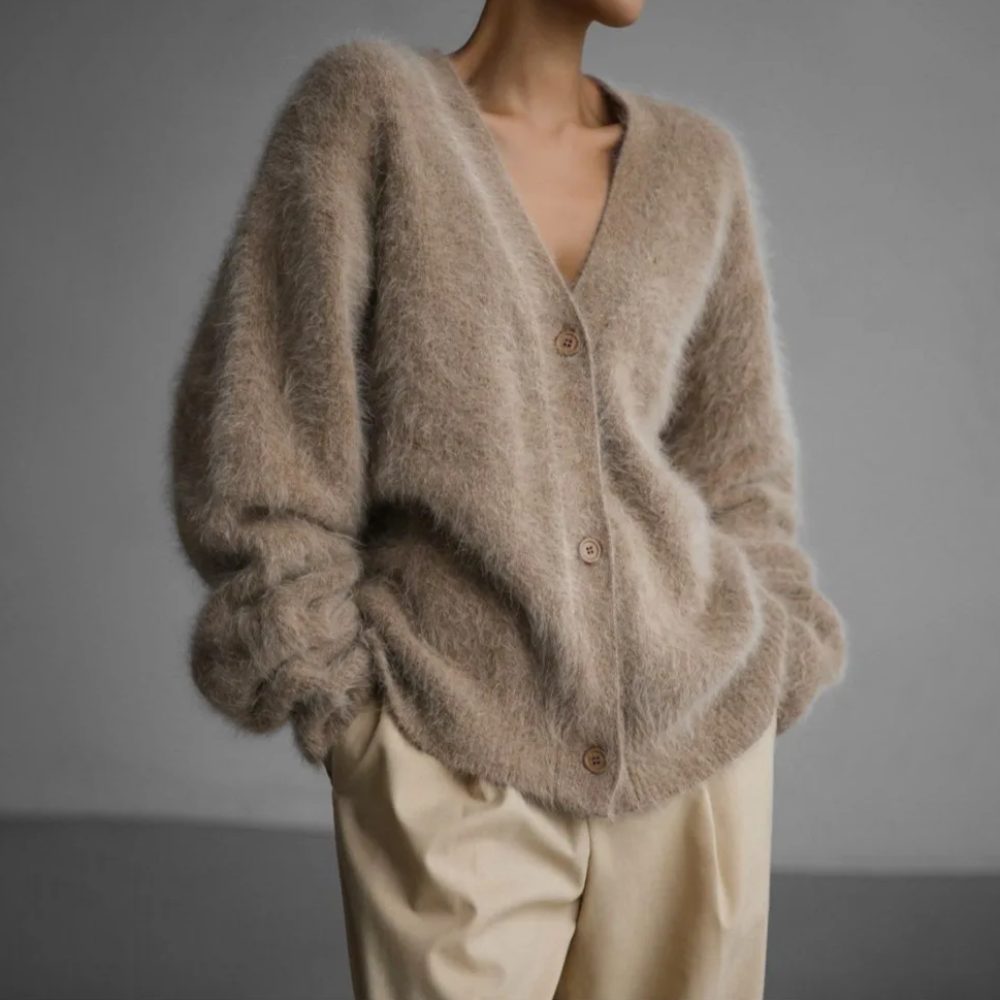 Woman wearing a soft button-front knit cardigan in a relaxed fit, styled for elegant autumn and winter layering.