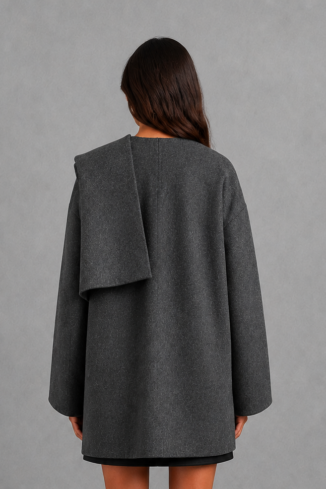 Women’s cape-style longline coat with a built-in scarf, flowing relaxed silhouette, soft cozy fabric, and elegant cold-weather design.
