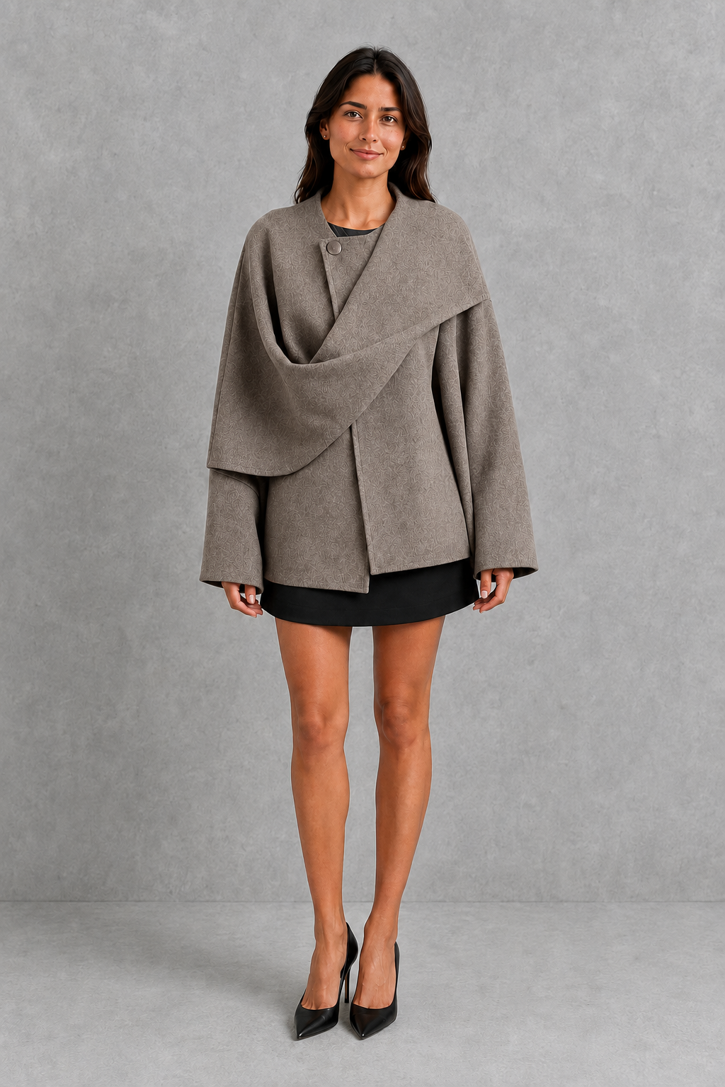 Women’s cape-style longline coat with a built-in scarf, flowing relaxed silhouette, soft cozy fabric, and elegant cold-weather design.
