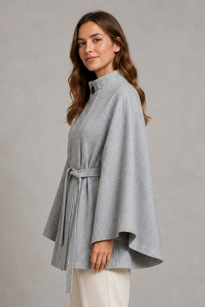 Women’s cape sleeve wool-look coat with a refined stand collar, belted waist, slim tailored fit, and structured statement silhouette.