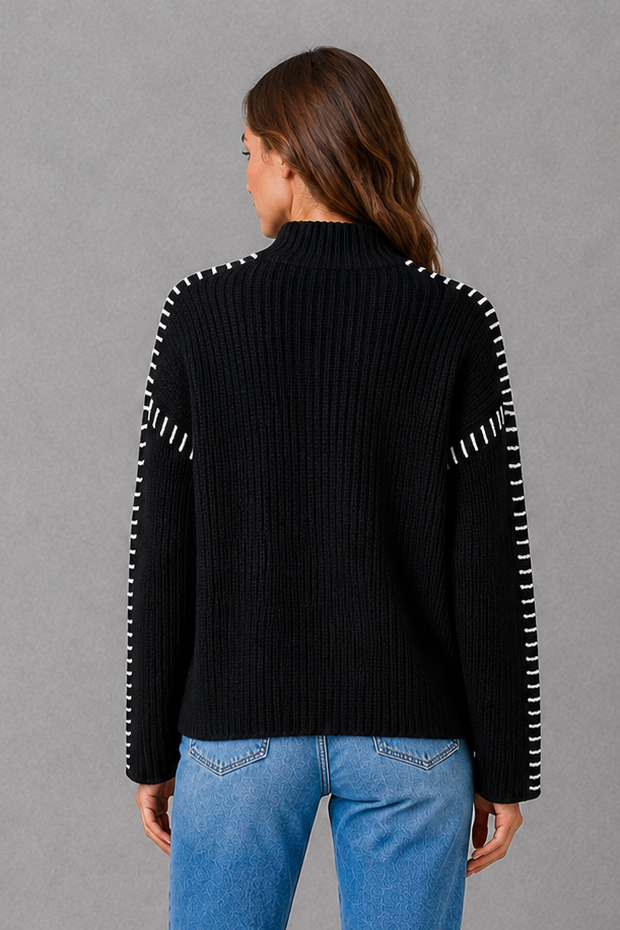 Women’s black oversized crew neck sweater with long sleeves and statement white contrast stitching along the shoulders and sleeves.