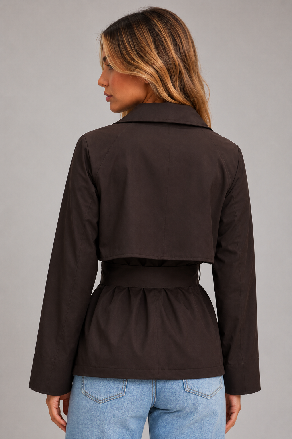 Women’s cropped trench jacket with a double-breasted front, structured lapel collar, storm flap and adjustable self-tie waist belt.