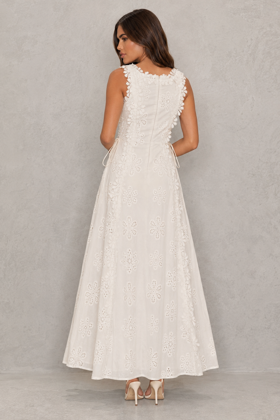 Women’s embroidered cotton maxi dress with floral detailing, a fitted bodice, lace accents, lace-up detail, and a flowing full-length skirt.