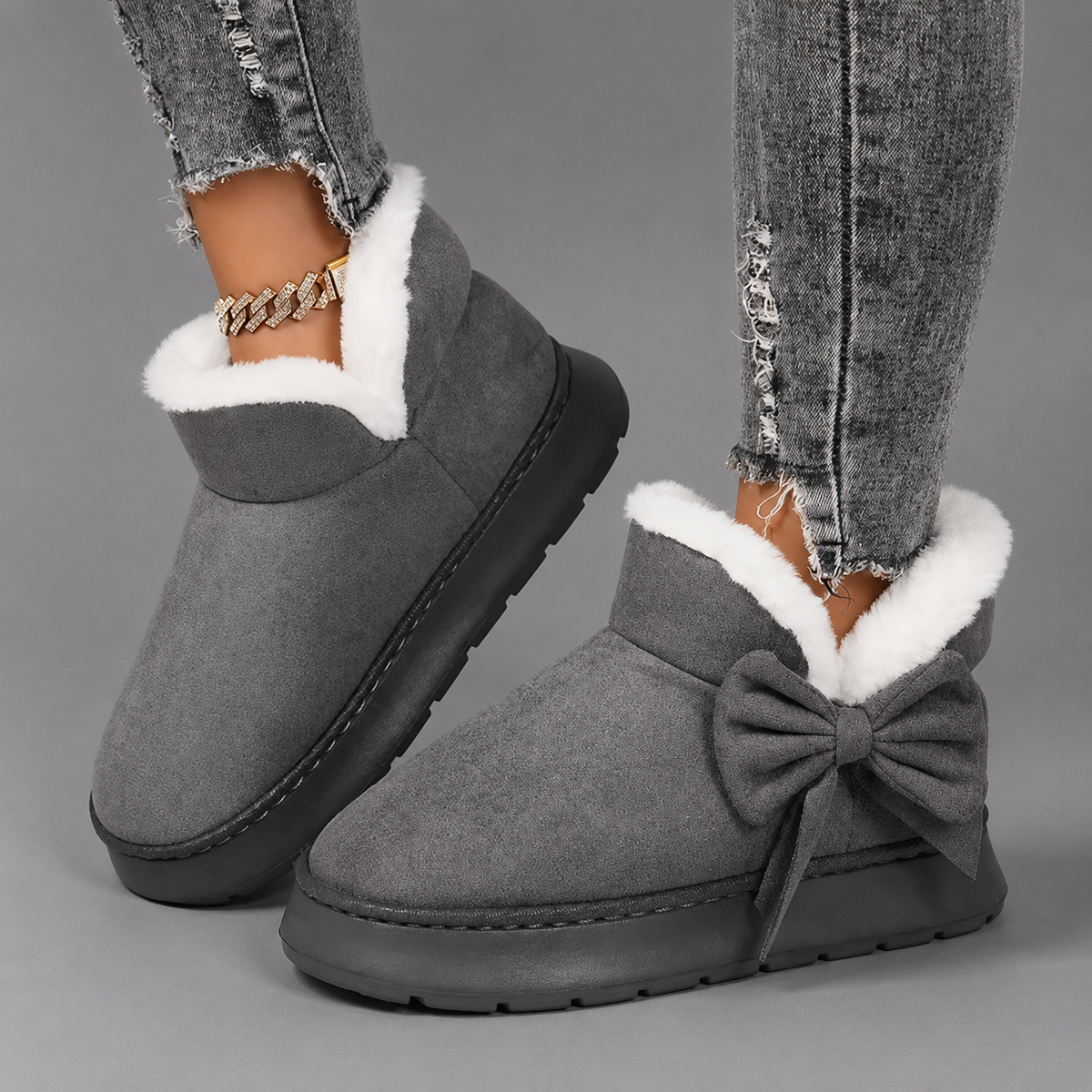Women’s fleece-lined slipper boots with a soft faux suede upper, plush lining, side bow detail, cushioned platform sole, and slip-on design.