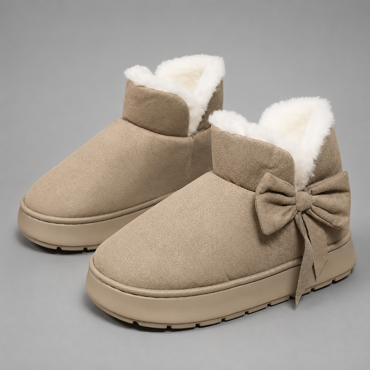 Women’s fleece-lined slipper boots with a soft faux suede upper, plush lining, side bow detail, cushioned platform sole, and slip-on design.