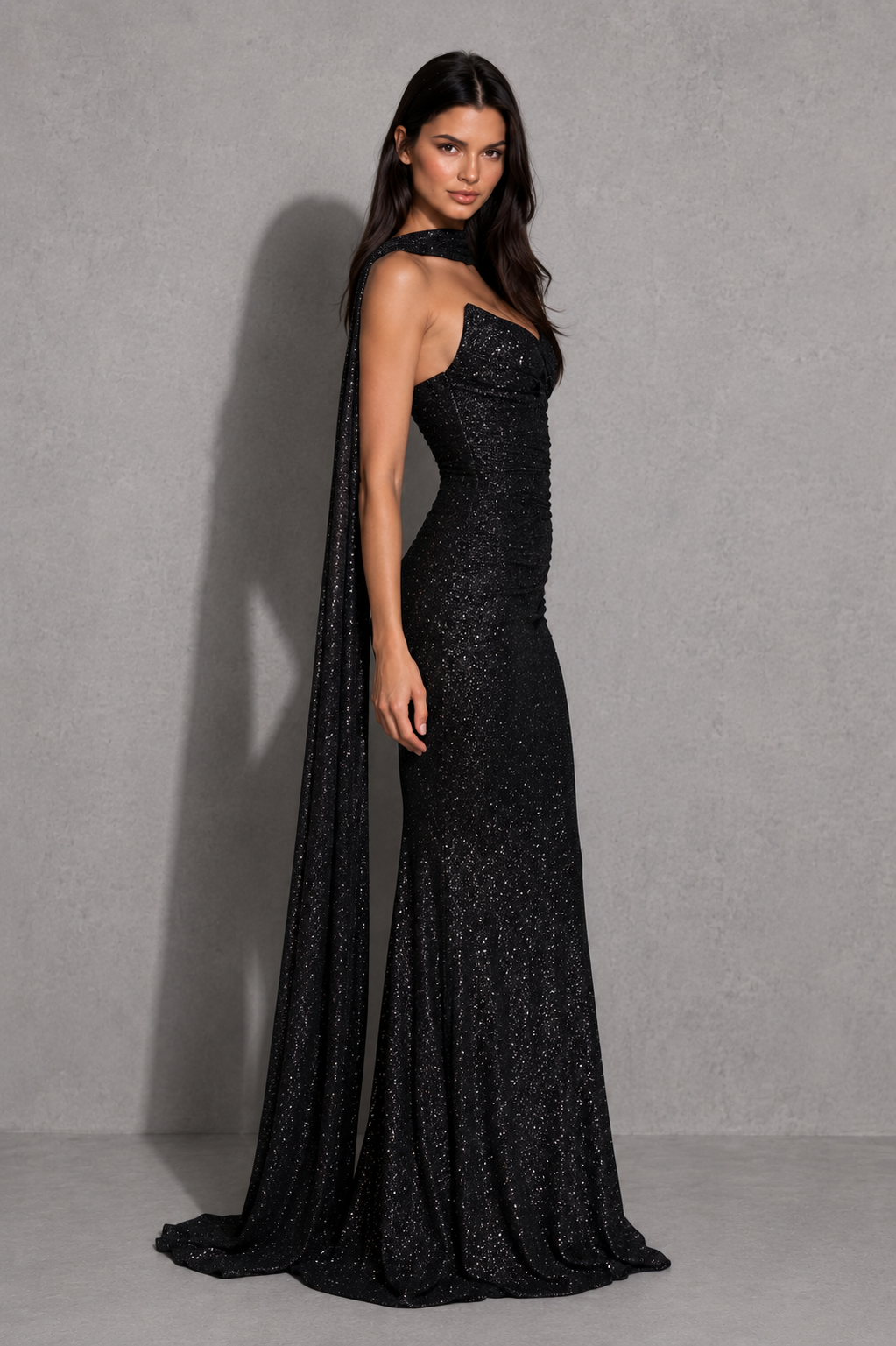 Women's glitter maxi dress with a strapless plunge neckline, wrap-effect ruched bodice, internal boning, draped hip panel, and flowing fit-and-flare godet skirt for elegant evening and formal occasions.