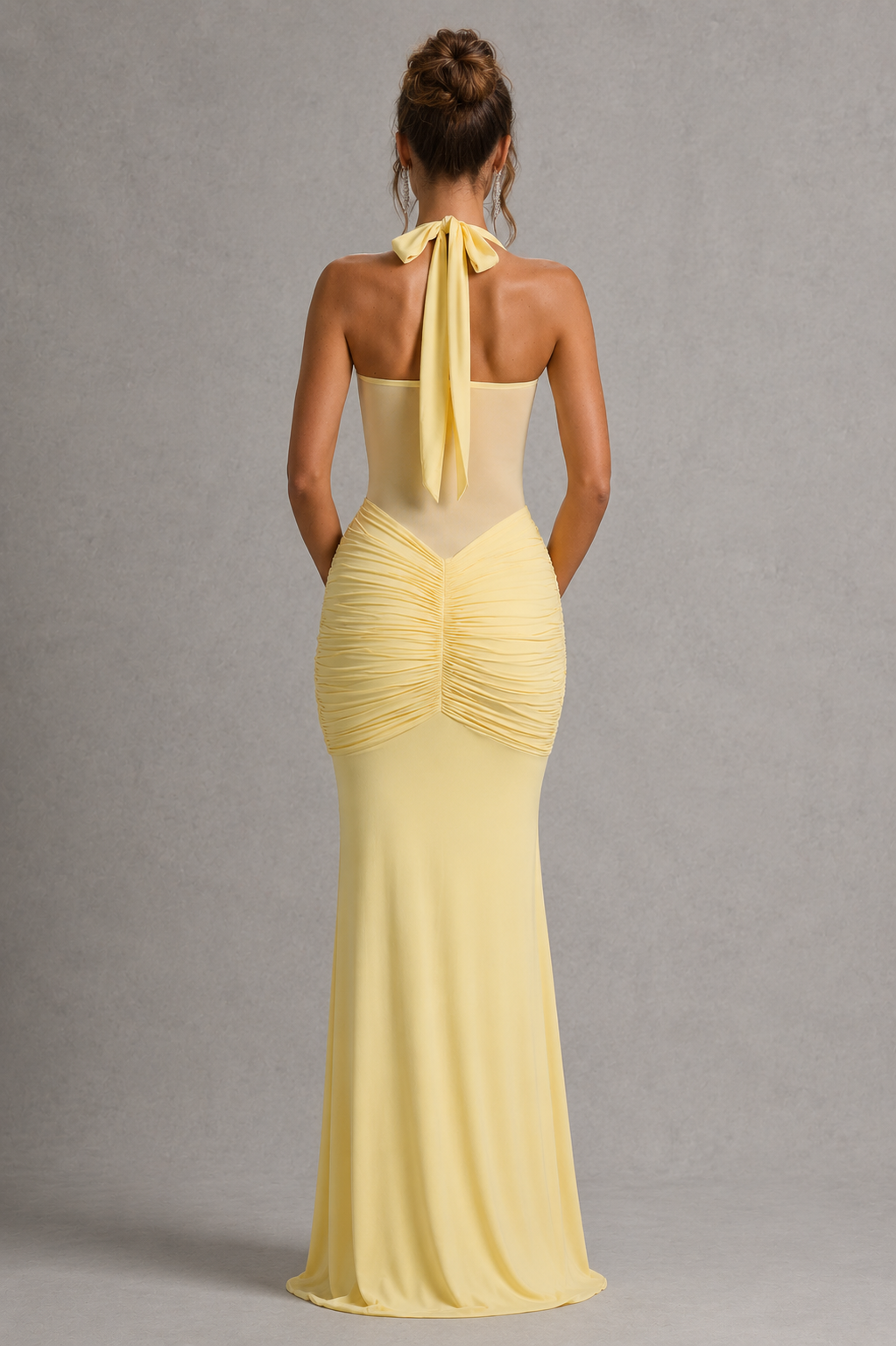 Woman wearing a women’s halter maxi dress with a sheer mesh bodice, sweetheart twist neckline, ruched hips, adjustable halter ties, and a flowing fit-and-flare skirt for evening and formal occasions.
