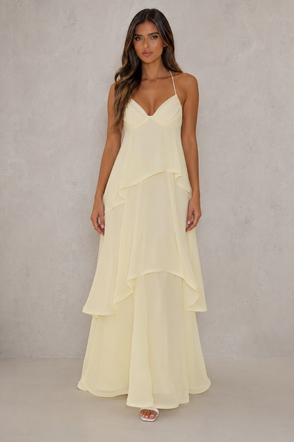 Women’s halter tiered maxi dress with V-neckline, self-tie straps, low open back and flowing layered floor-length skirt.