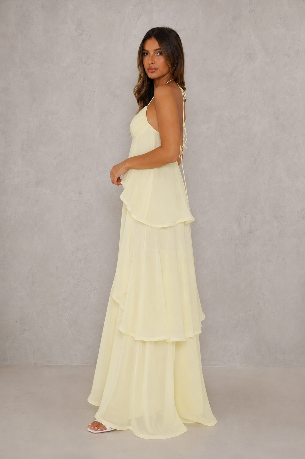 Women’s halter tiered maxi dress with V-neckline, self-tie straps, low open back and flowing layered floor-length skirt.
