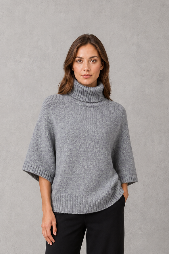 Women’s high neck batwing knit sweater with textured detailing, relaxed poncho-style silhouette, flowing sleeves, and a flattering waist-defining shape.