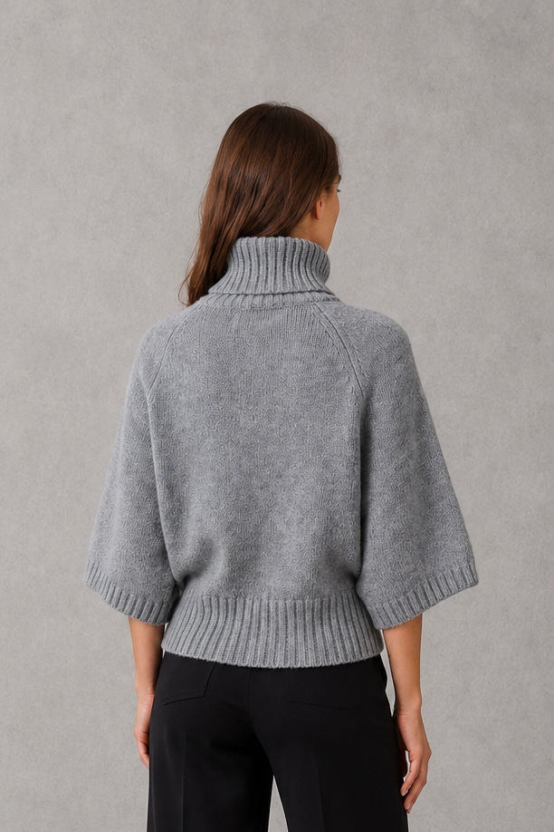 Women’s high neck batwing knit sweater with textured detailing, relaxed poncho-style silhouette, flowing sleeves, and a flattering waist-defining shape.