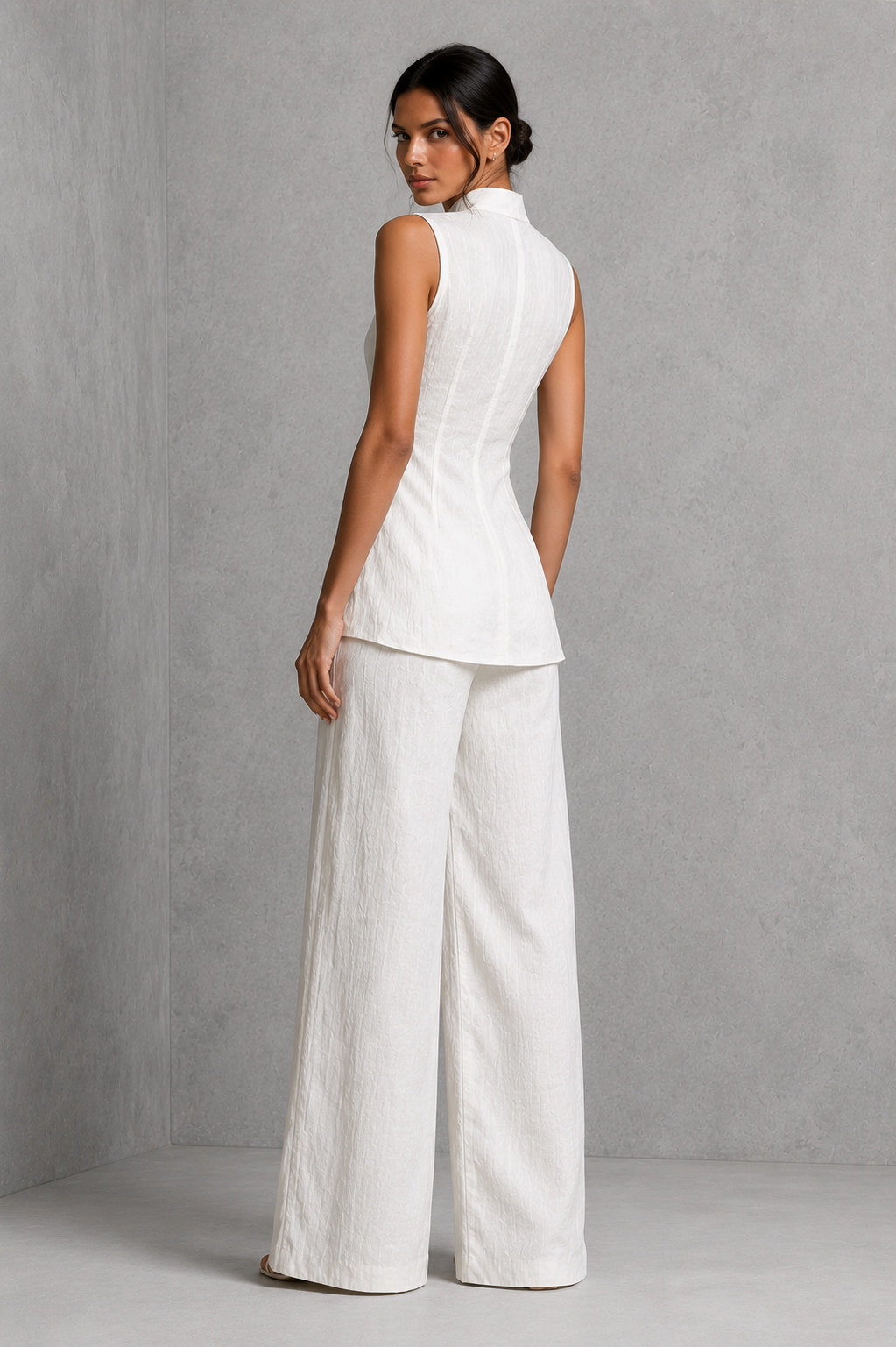 Women’s two-piece set featuring a sleeveless high-neck button-front top with a layered hem and matching flowing wide-leg pants.