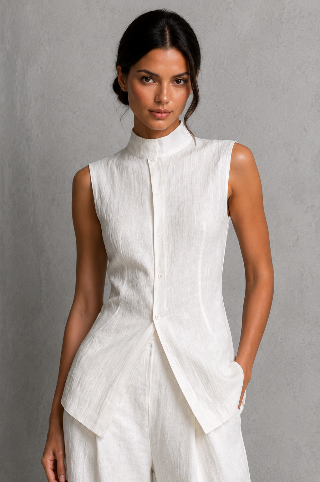 Women’s two-piece set featuring a sleeveless high-neck button-front top with a layered hem and matching flowing wide-leg pants.