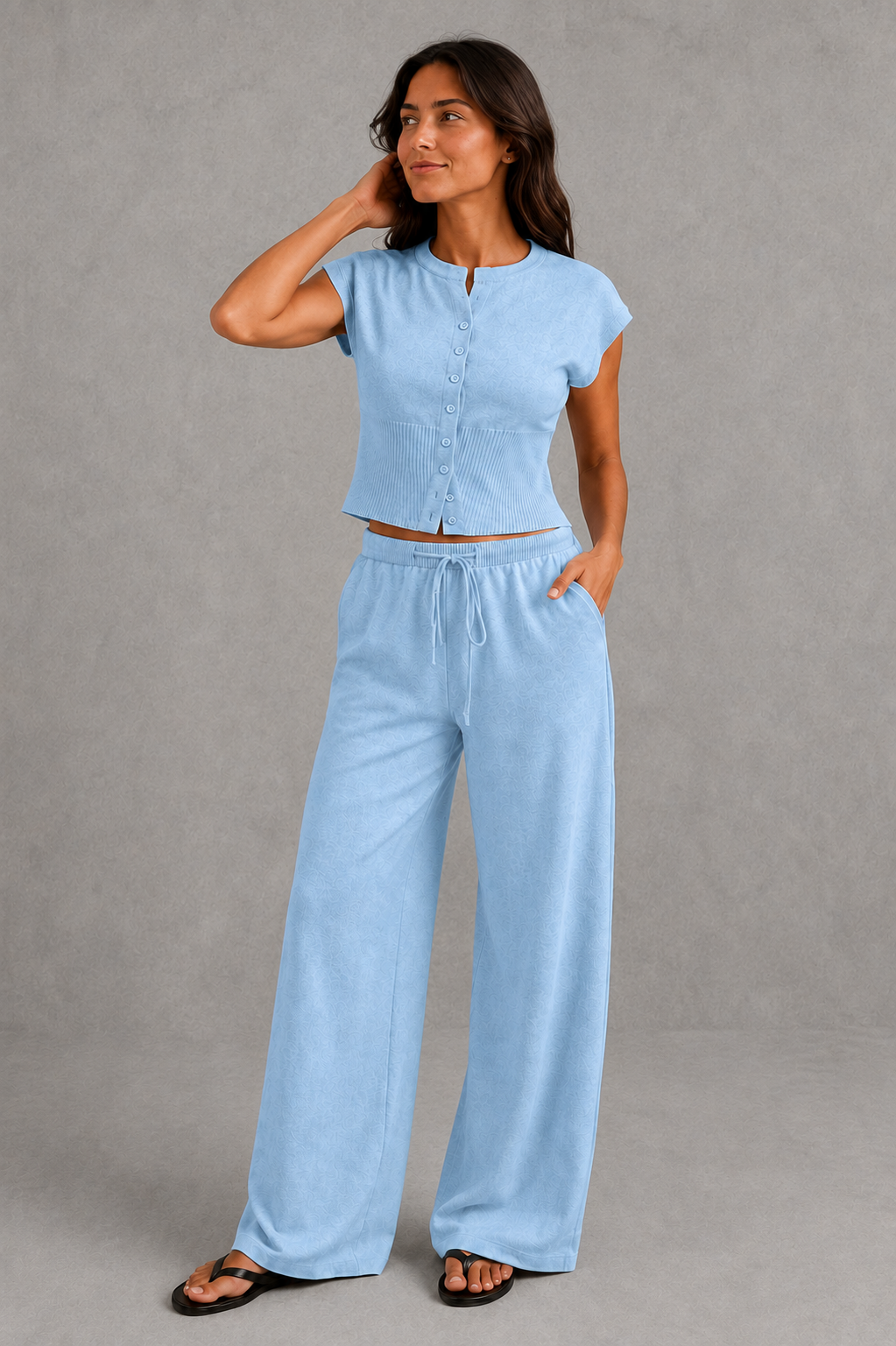 Women’s knit two-piece set featuring a sleeveless button-front top with ribbed waist detailing and matching drawstring wide-leg pants.