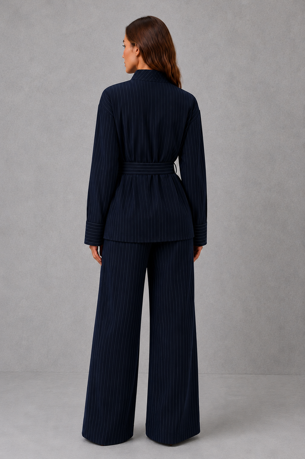 Women’s navy pinstripe two-piece set featuring a long-sleeve high-neck top with a belted waist and matching wide-leg pants.