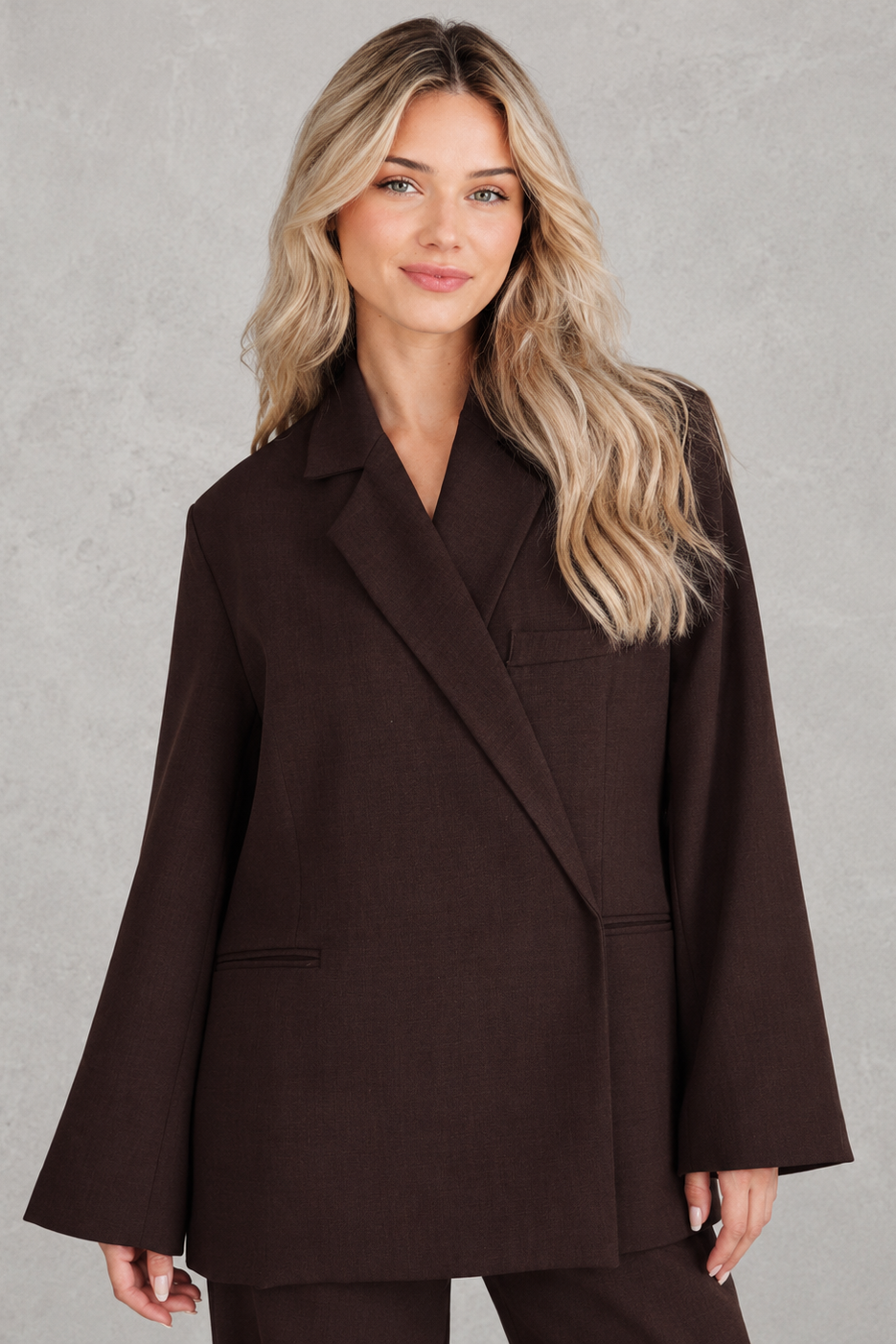 Women’s oversized asymmetrical blazer with a modern button-front closure, structured shoulders, side slits, and a relaxed tailored silhouette.