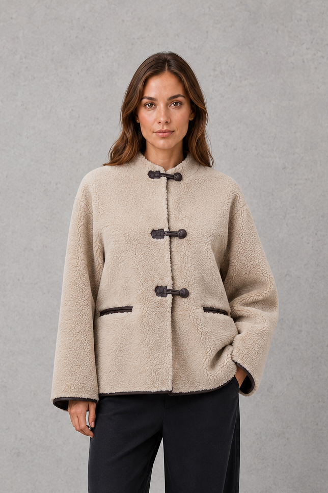 Women’s oversized faux fur toggle jacket with a soft plush texture, contrast trim, classic toggle closures, and two functional front pockets.