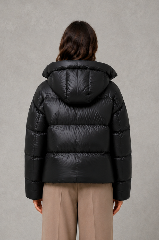 Women’s oversized hooded puffer jacket with generous padding, a large protective hood, high collar and wide long sleeves for cozy cold-weather coverage.