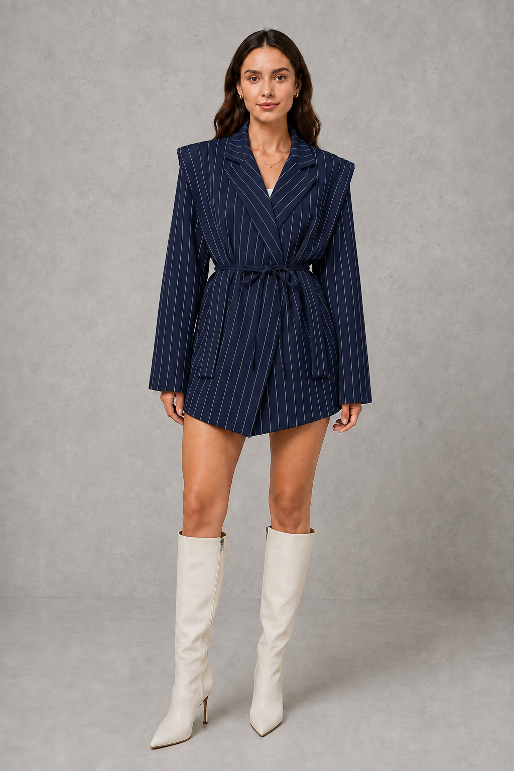 Women’s pinstripe belted longline blazer with structured shoulders, classic lapels, fine vertical stripes, long sleeves, and an adjustable self-tie waist.