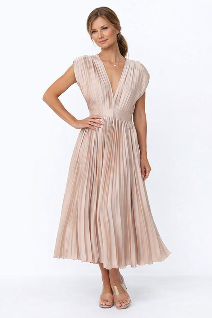 Woman wearing a beige pleated dress on a white background
