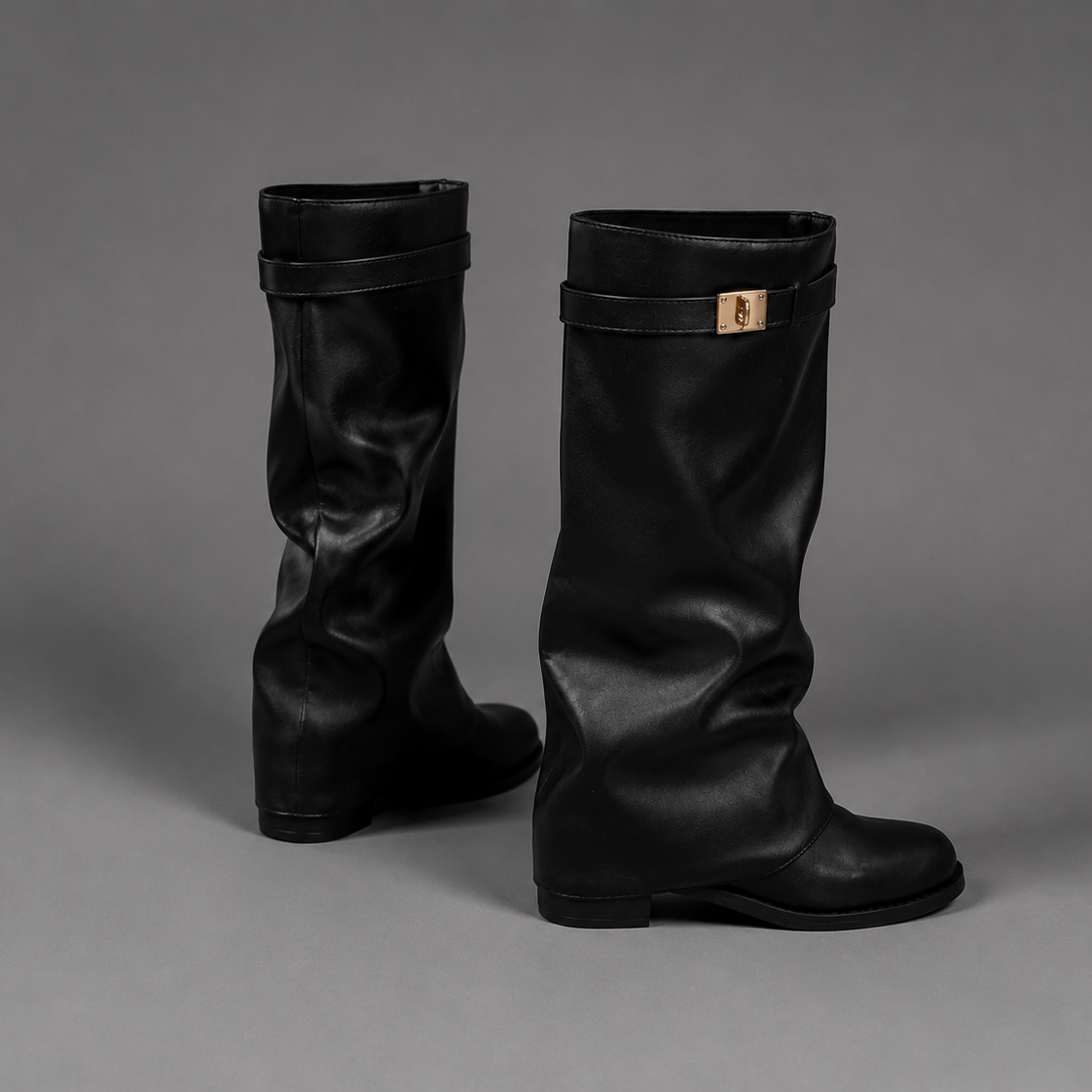 Women’s pointed toe slouch knee-high boots with a relaxed shaft, low block heel, pull-on design, and polished metal cuff detail.