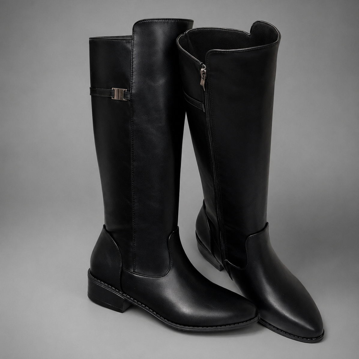 Women’s pointed toe slouch knee-high boots with a relaxed shaft, low block heel, pull-on design, and polished metal cuff detail.