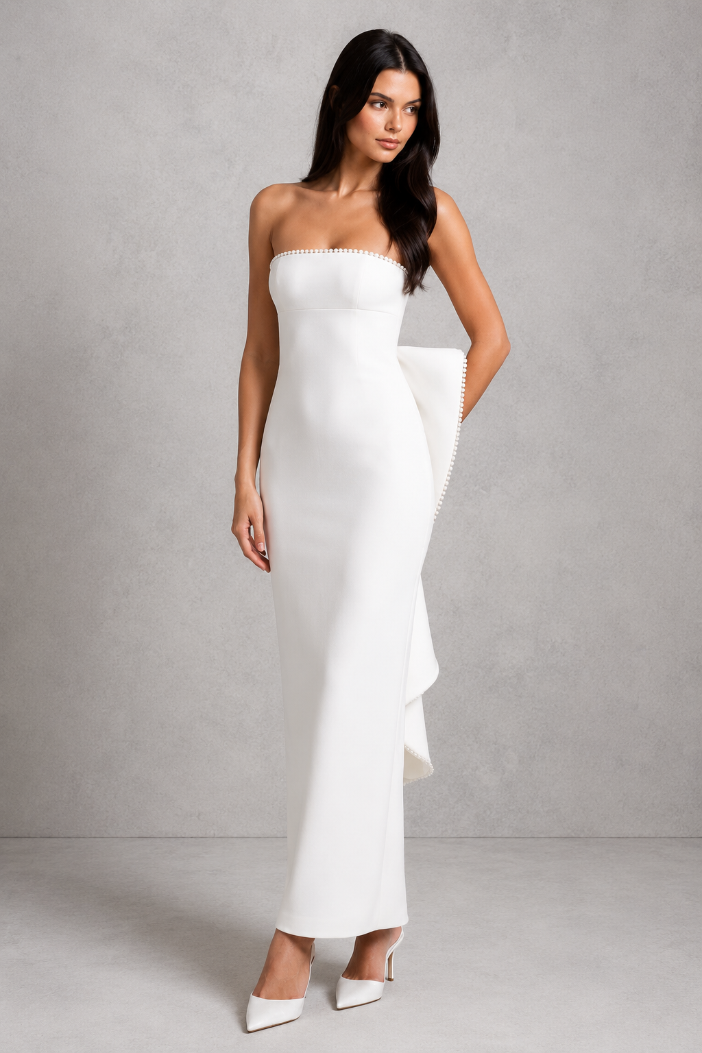 Women's strapless maxi dress in structured crepe featuring a pearl-trimmed neckline, fitted bodice, defined waist, sleek column skirt, centre back split, and detachable oversized bow for elegant evening and formal occasions.