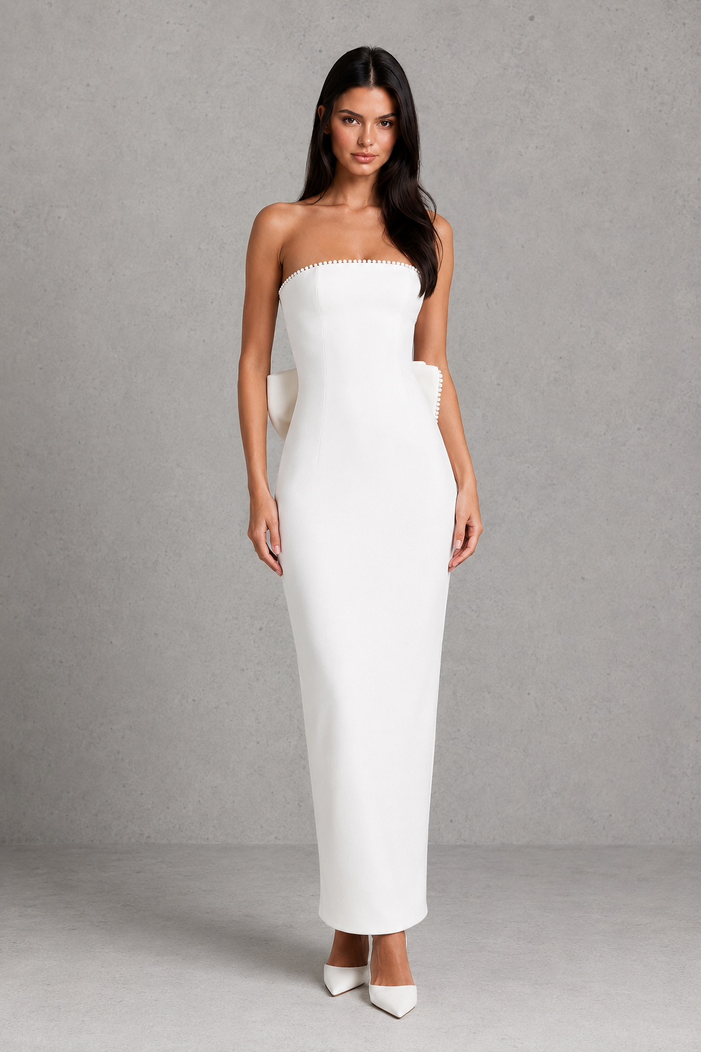Women's strapless maxi dress in structured crepe featuring a pearl-trimmed neckline, fitted bodice, defined waist, sleek column skirt, centre back split, and detachable oversized bow for elegant evening and formal occasions.