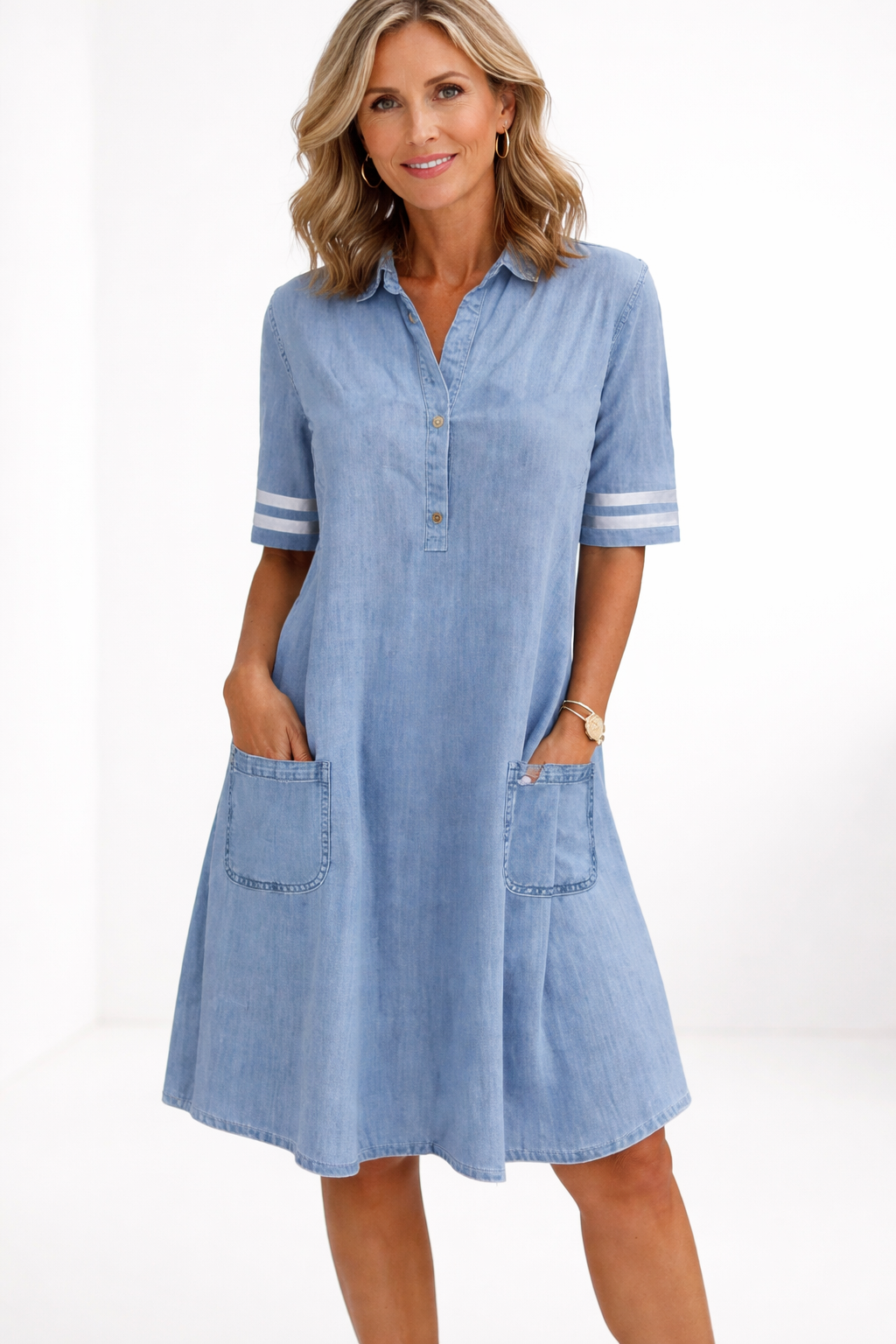Woman wearing a light blue denim dress on a white background