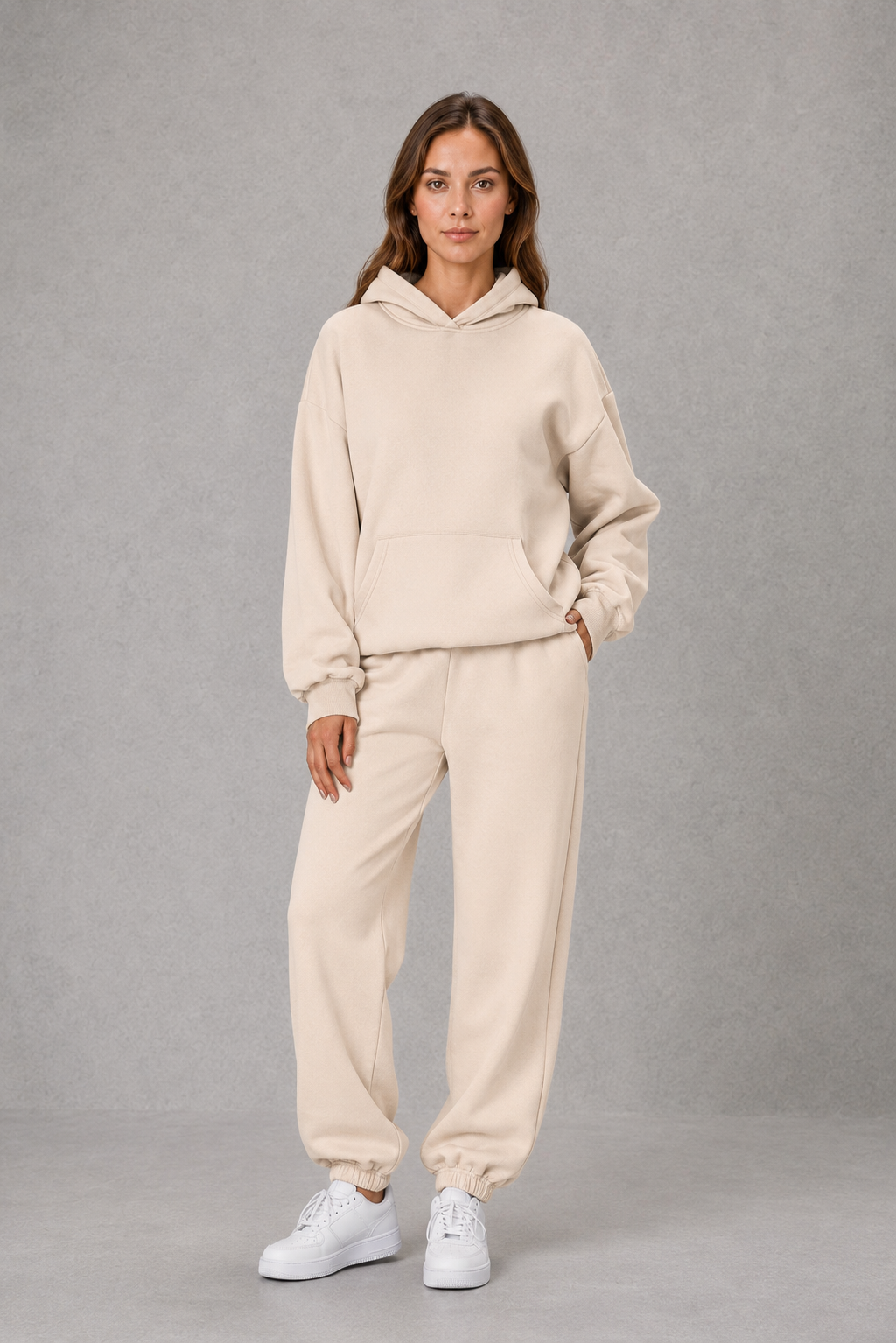 Women’s two-piece tracksuit set featuring a relaxed drawstring hoodie with front pocket and matching tapered jogger pants with cuffed ankles.