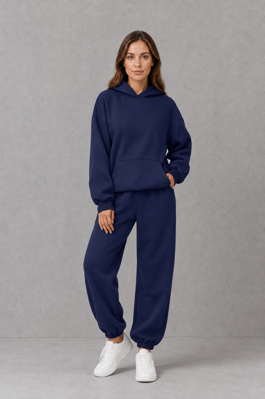 Women’s two-piece tracksuit set featuring a relaxed drawstring hoodie with front pocket and matching tapered jogger pants with cuffed ankles.