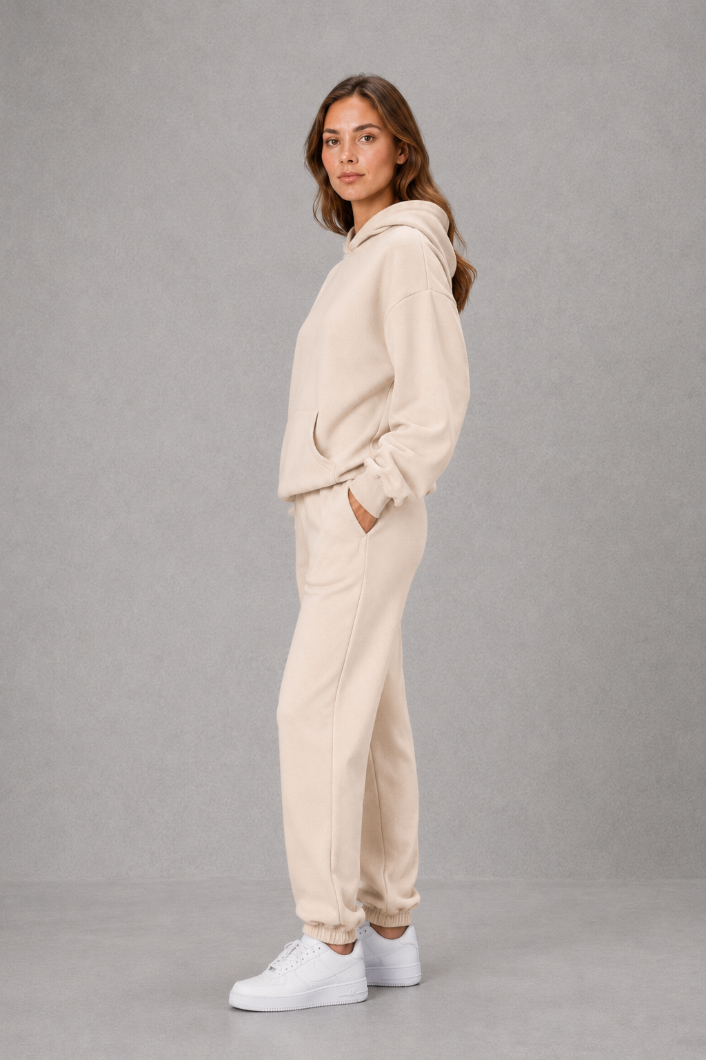 Women’s two-piece tracksuit set featuring a relaxed drawstring hoodie with front pocket and matching tapered jogger pants with cuffed ankles.